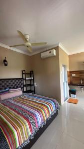 珍南海滩Cenang Room Rahsia Motel的一间卧室配有一张床和吊扇