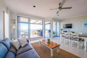 Port WillungaPort Willunga Ocean Views Beachhouse的客厅配有蓝色的沙发和桌子