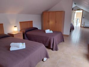 萨莫斯Hospedería Externa del Monasterio的酒店客房,配有两张带紫色床单的床