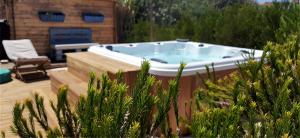 萨格里什Blacksheep Sagres Guesthouse & Surf的植物庭院内的按摩浴缸