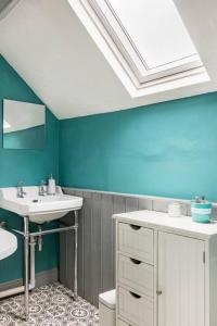尼思Tŷ Selah, Rugby Ave, Neath的浴室设有白色水槽和蓝色的墙壁