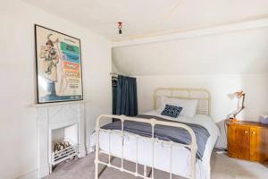尼思Tŷ Selah, Rugby Ave, Neath的卧室配有白色的床和壁炉