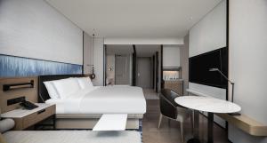 广州Guangzhou Marriott Hotel Nansha的酒店客房设有一张床、一张书桌和一台电视机。