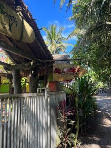 PasanggaranBig Daddy´s Surfcamp的棕榈树建筑上标有标志的餐厅