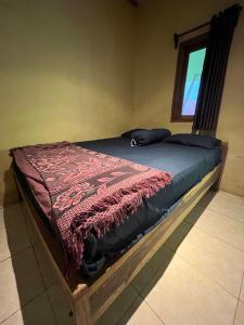 PasanggaranBig Daddy´s Surfcamp的一张床上的红色毯子,放在一个房间里