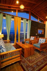 阿尔莫拉Shivoham Himalayan Resort的客厅配有木制家具和大窗户