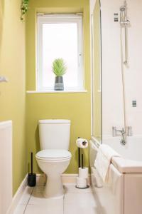KillingbeckKandaka-Specious Stylish Home - Suitable for Contractors的一间带卫生间的浴室和一个带盆栽的窗户