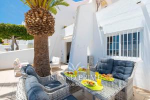 圣米格尔德阿沃纳Seaviews 2x Bedroom Apartment in Sand Club Complex的一个带桌椅和棕榈树的庭院