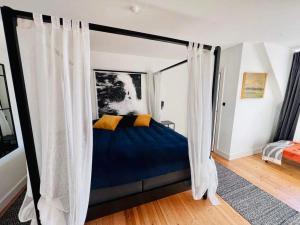 斯泰厄Stege Torv Family Apartment的一间卧室配有带窗帘的天蓬床