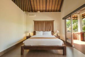 乌布Artini Bisma Ubud Hotel的一间卧室设有一张床和一个大窗户