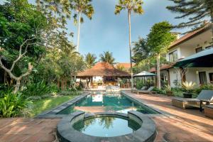 乌布Artini Bisma Ubud Hotel的棕榈树度假村的游泳池形象