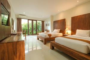 乌布Artini Bisma Ubud Hotel的酒店客房设有两张床和电视。