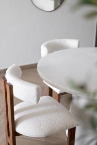 迪拜TH-Homes scandinavia interior 1 BR at Wasl 1的一张白色的桌子和一张桌子旁的白色椅子