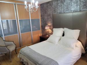 格拉纳达Privada Confort Granada的卧室配有白色的床和吊灯。