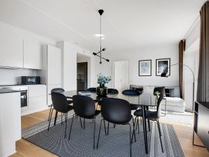 哥本哈根Sanders Arena - Chic Three-Bedroom Apartment Close to Metro Station的厨房以及带桌椅的用餐室。
