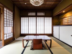 出云市Nipponia Izumo Hirata Cotton Road的客房设有桌子、椅子和窗户。