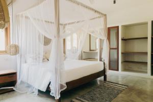 KalametiyaOcean Divine的卧室配有带白色窗帘的天蓬床