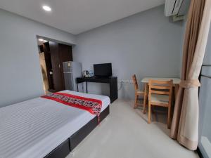 曼谷Tiara Place的一间小卧室,配有一张床和一张桌子及椅子