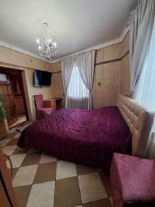 切尔诺夫策Zatyshok的一间卧室配有一张大紫色床和两把椅子