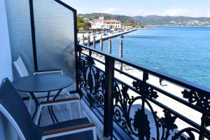 伊西翁Leonidas Hotel的阳台配有桌椅和水