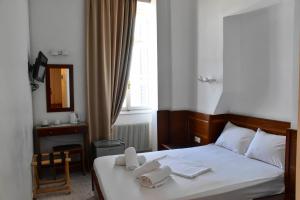 伊西翁Leonidas Hotel的一间卧室配有一张床,上面有两条毛巾