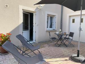 芒德Studio cosy的庭院配有椅子、遮阳伞和桌子。