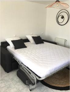 芒德Studio cosy的客房内的一张带黑色枕头的白色床