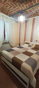 Villanova dʼAstiAppartamento Lucia的一间卧室设有一张大床和格子天花板