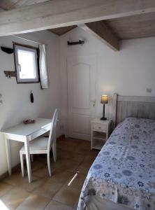 雷岛圣玛丽Les Bois Flottés en Ré的一间卧室配有一张床、一张桌子和一个窗户。