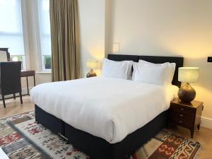 巴尔内特Glenlyn Hotel & Apartments的卧室配有一张带白色床单和枕头的大床。