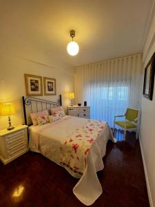 阿尔马达Cocas House II - Almada的一间卧室配有一张床、一盏灯和一把椅子