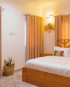 阿克拉The Avery Apartments, Dzorwulu的一间卧室配有橙色窗帘的床