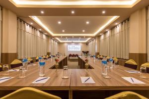 图利凯尔Hotel Sarathi的大型会议室,配有长桌子和椅子
