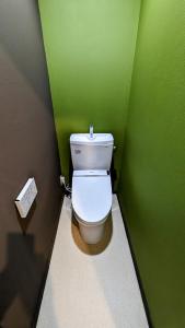 富士吉田市富士吉田たまきや的浴室设有绿色墙壁上的白色卫生间