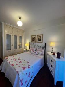 阿尔马达Cocas House II - Almada的一间卧室配有一张大床和一个蓝色梳妆台