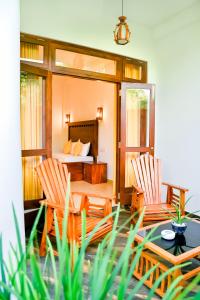 本托塔Villa Paradise Ocean的一间卧室配有一张床、两把椅子和一张桌子