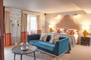 浦耳普尔酒酒店的酒店客房,配有床和蓝色的沙发