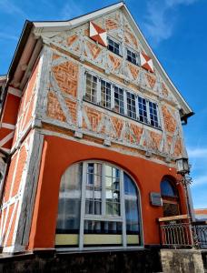 维斯马Ferienwohnungen im Gewölbe的一座橙色和白色的建筑,设有窗户