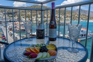 伊罗达Aristea Hotel的一张桌子,上面放着一盘水果和一瓶葡萄酒