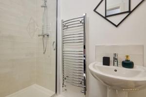 海丁利Stunning 5Bed All En-suite Headingley Home的白色的浴室设有水槽和淋浴。