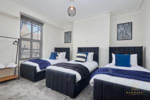 海丁利Stunning 5Bed All En-suite Headingley Home的一间卧室配有两张带蓝白色床单的床