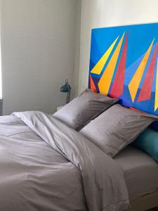 米卢斯King size lounge 76m2 de confort au centre ville的一张带色彩缤纷床头板和枕头的床