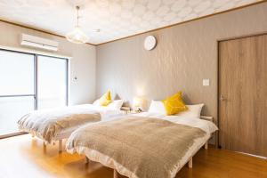 白滨Sayuragi Villa 白浜的墙上挂钟的房间里设有两张床