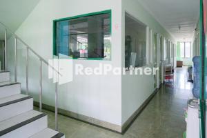 泗水Pondok Hijau Syariah Mitra RedDoorz At Citraland Surabaya的走廊上设有楼梯和窗户的建筑