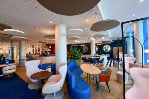 敦刻尔克Mercure Dunkerque Centre Gare的餐厅设有蓝色和白色的椅子和桌子