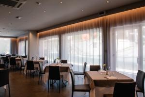 莫迪卡普林奇比德阿拉戈纳酒店的餐厅设有桌椅和大窗户。