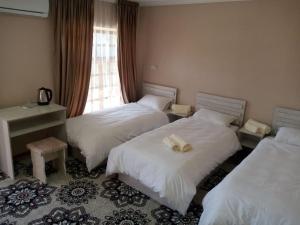 撒马尔罕Istirohat guest house的酒店客房设有两张床和窗户。
