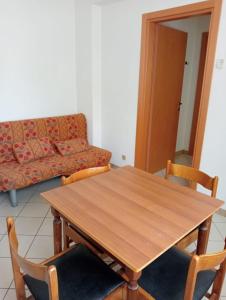 里米尼Appartamenti Carlotta的客厅配有沙发和木桌及椅子