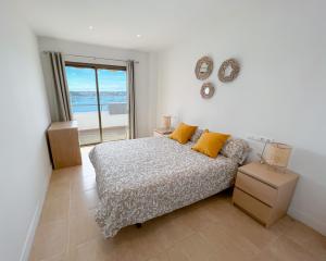 拉萨维纳Turquesa & Ambar Apartments Formentera的一间卧室配有一张床,享有海景