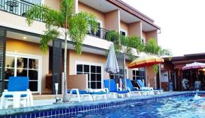 邦萨雷4 Palms Resort的一座带椅子和遮阳伞的游泳池位于一座建筑旁边